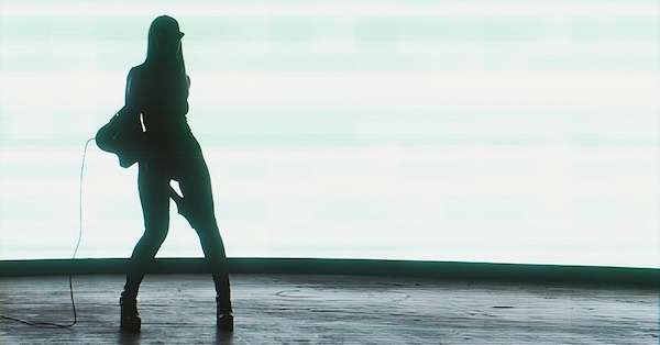 Android-looking woman standing, holding an electric guitar in her right hand